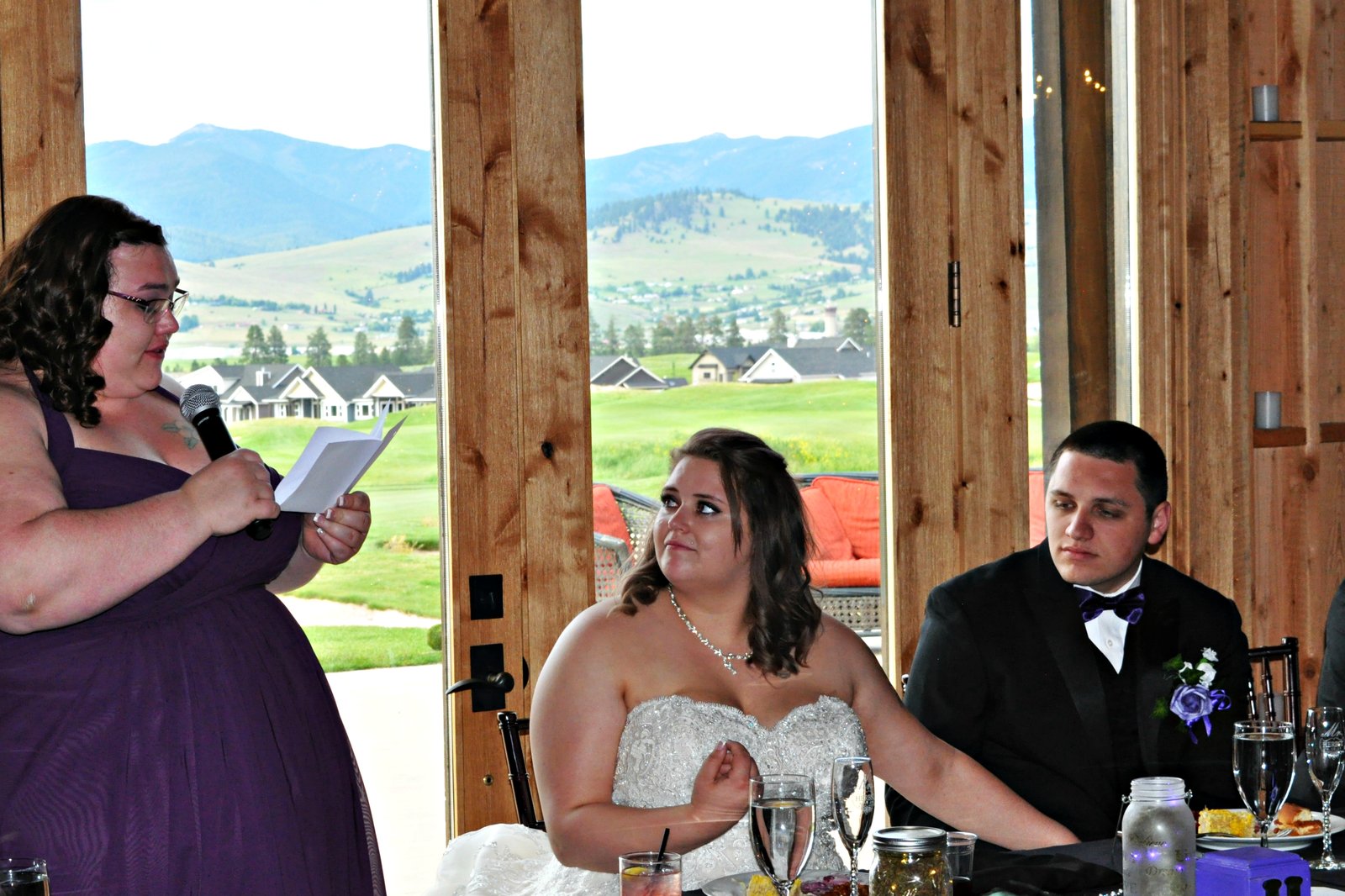 Maid of honor toast with mountain view through barn windows